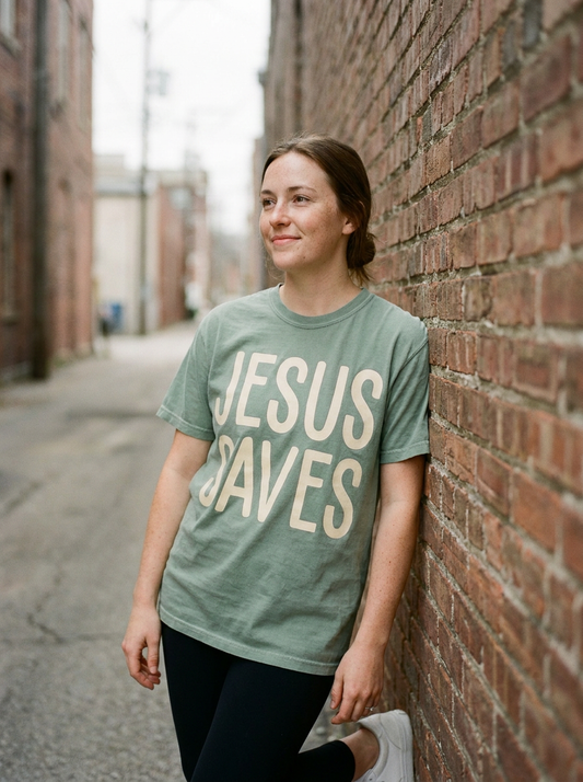 Jesus Saves shirt worn, oversized cream lettering on sage green