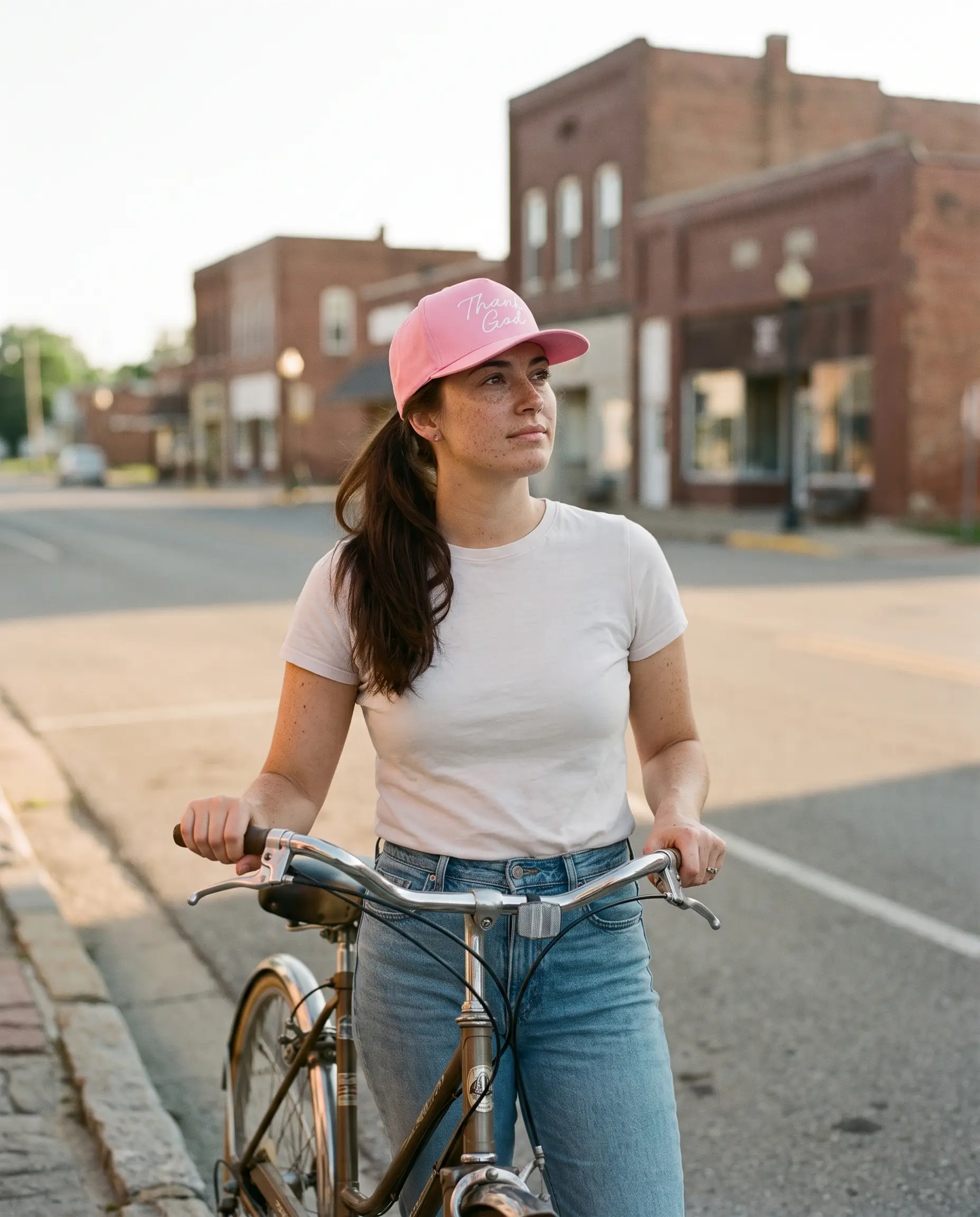 Model wearing the Thank God Script Hat, White on Pink, second view