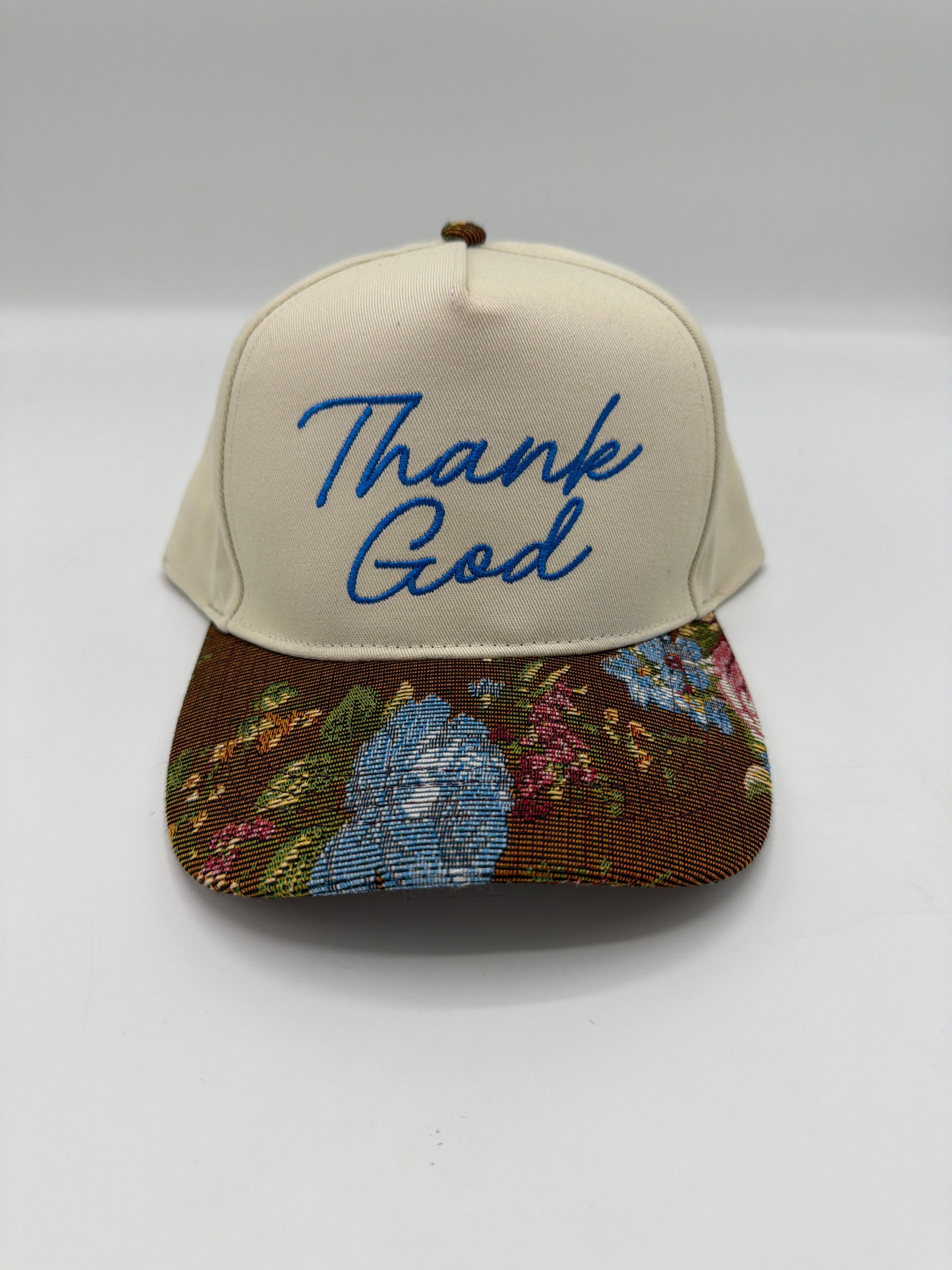 Thank God in royal blue script on a cream crown with a brown floral tapestry brim