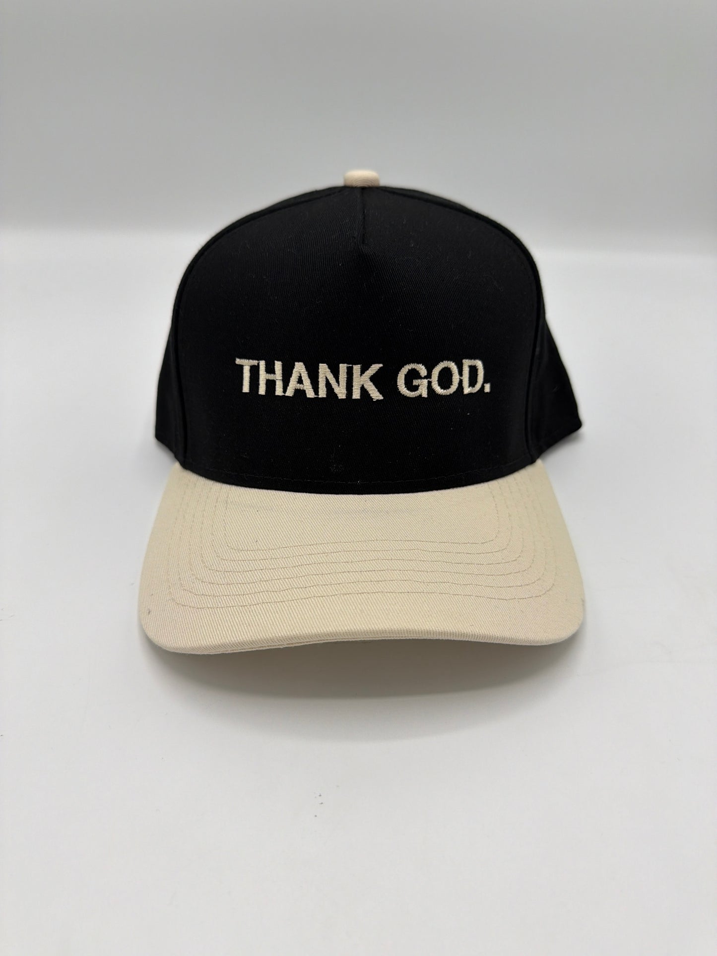 Thank God in cream puff embroidery on a black crown with a cream brim