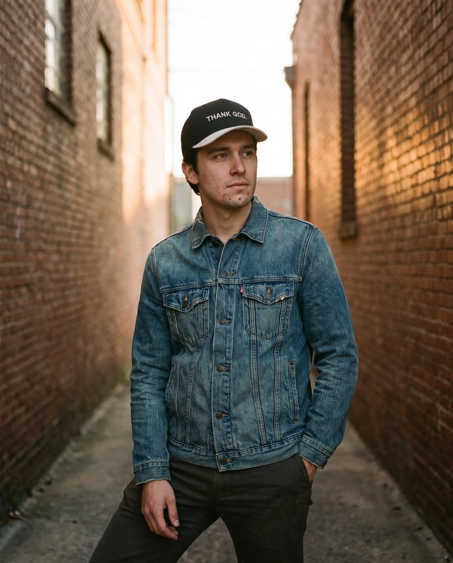 Model wearing the Thank God Hat, Black and Cream, second view