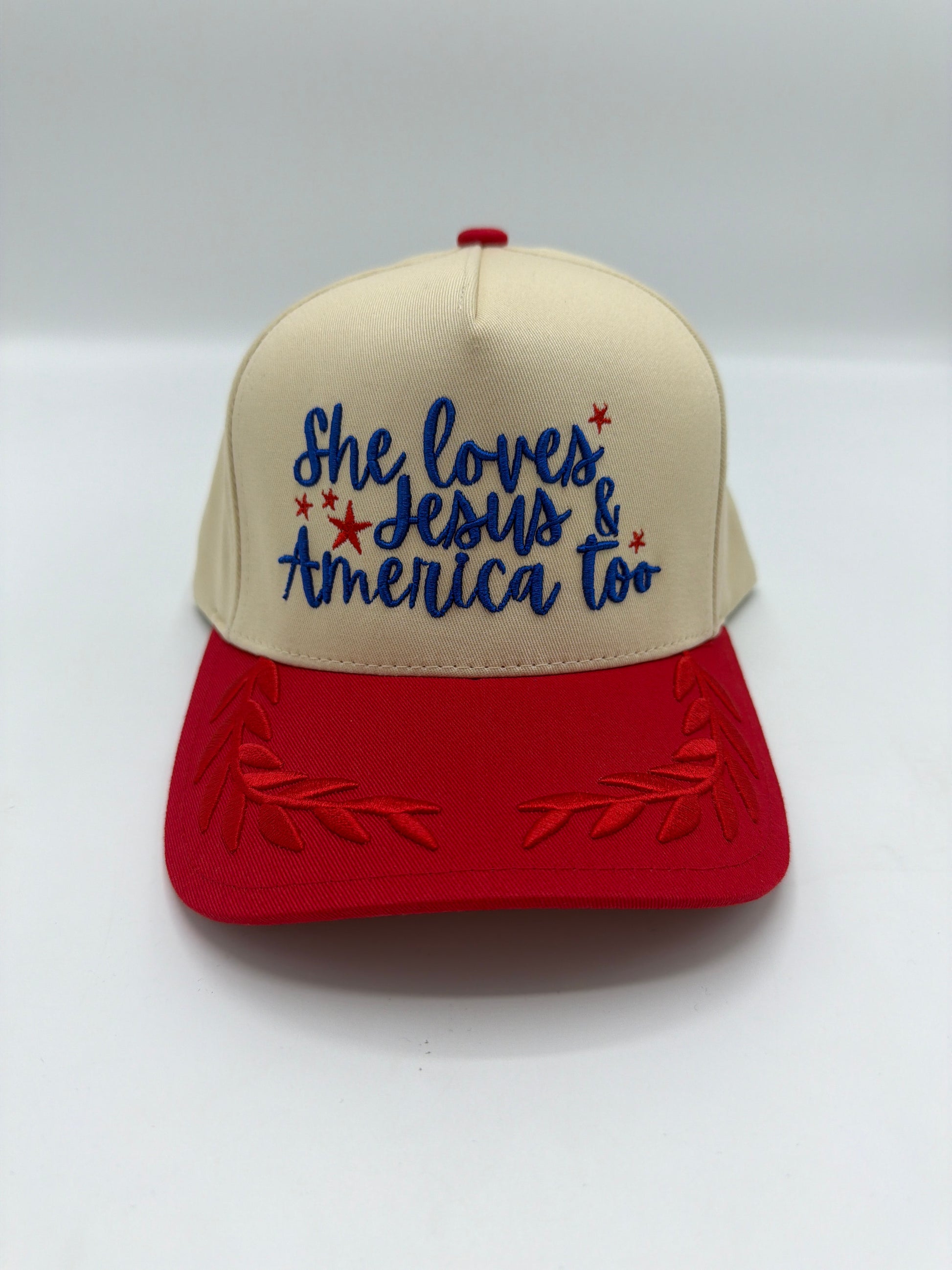 She Loves Jesus and America Too hat, cream crown with blue script and a red laurel leaf brim