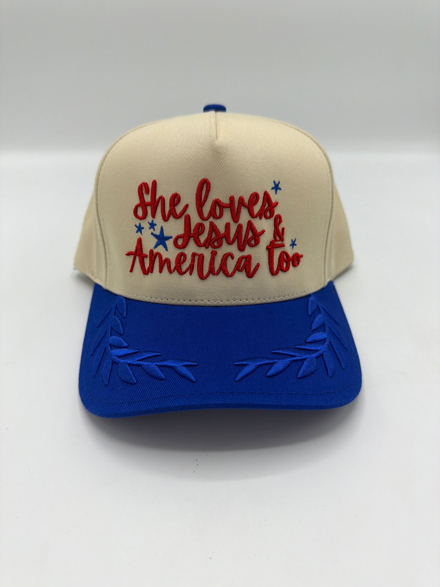 She Loves Jesus and America Too hat, cream crown with red script and a royal blue laurel leaf brim