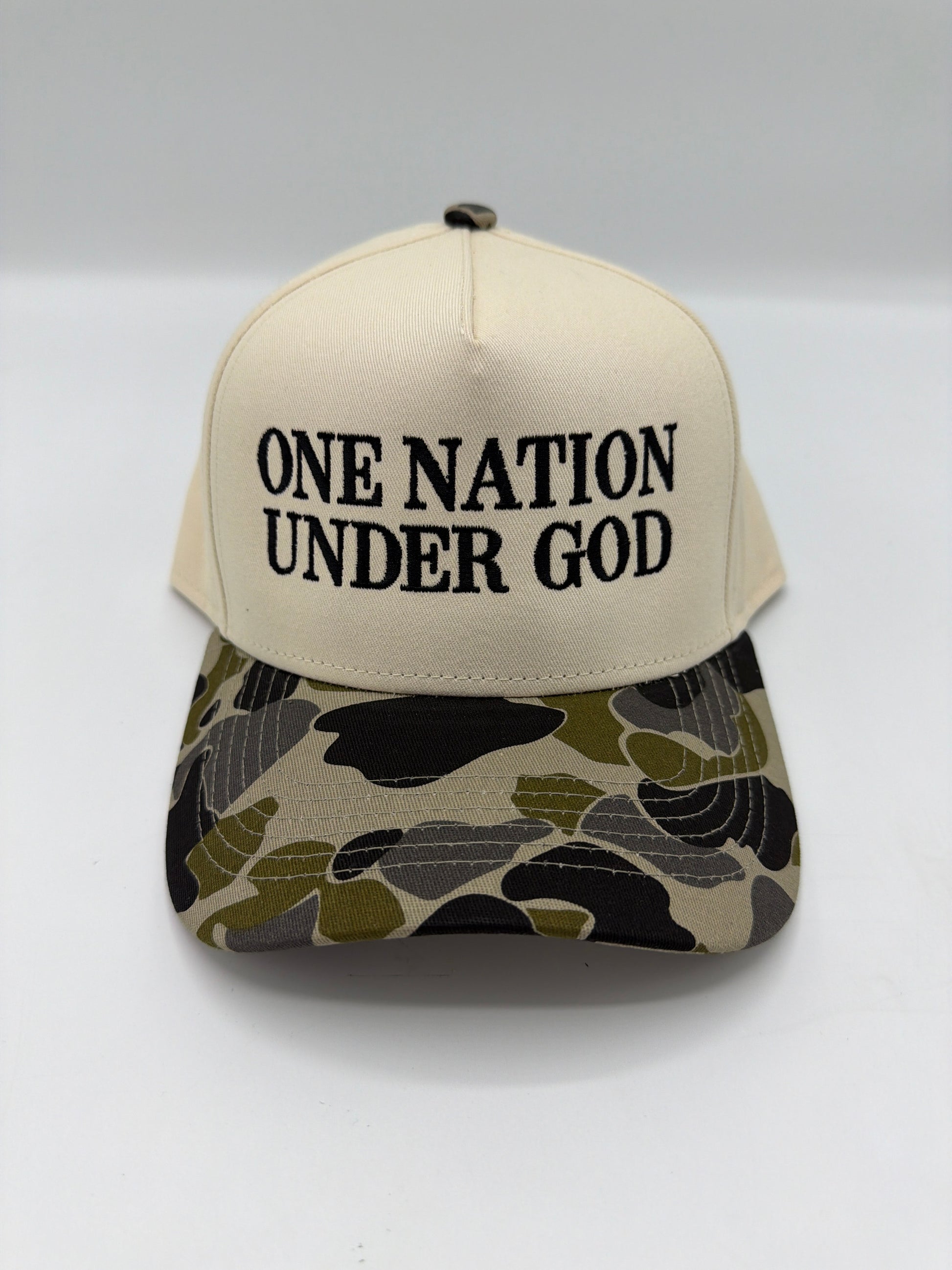 One Nation Under God embroidered in black serif on a cream crown with a duck camo brim