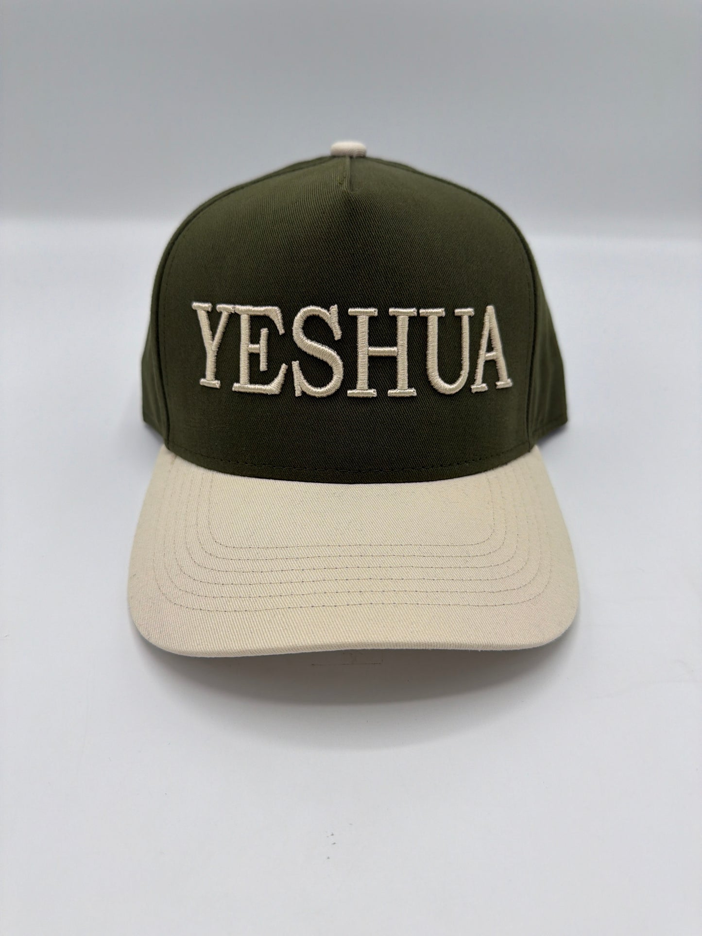 Yeshua embroidered in cream on an olive five panel snapback with a cream brim