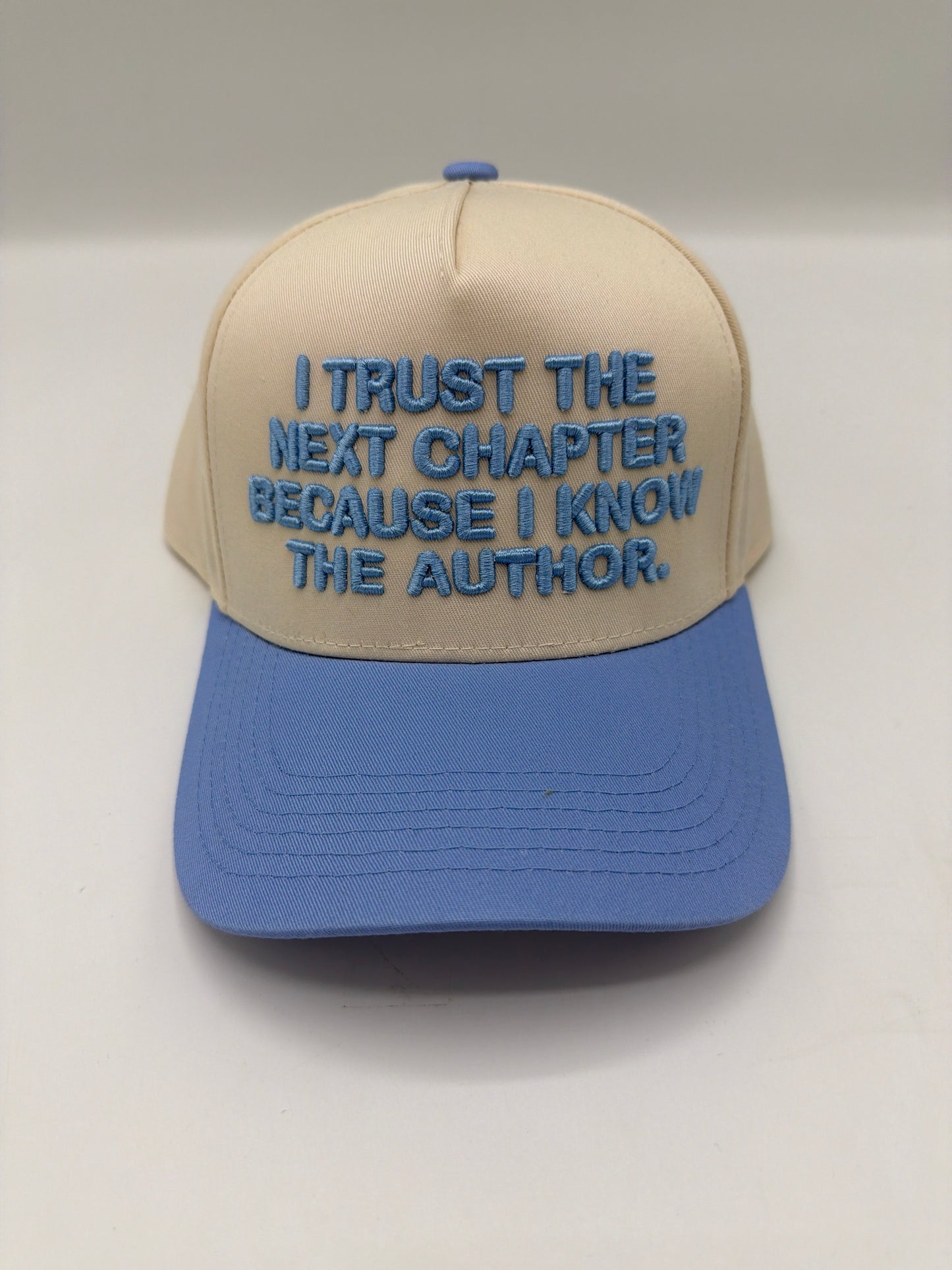 I trust the next chapter because I know the Author, embroidered on a cream crown with a periwinkle brim