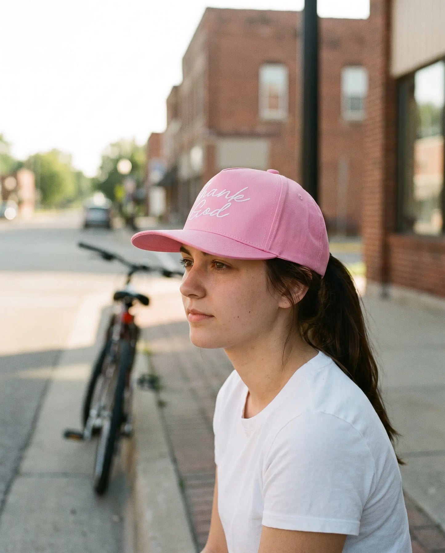 Model wearing the Thank God Script Hat, White on Pink